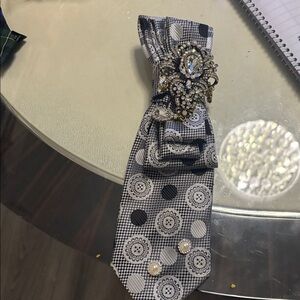Elegant Black and White Patterned Tie with Brooch